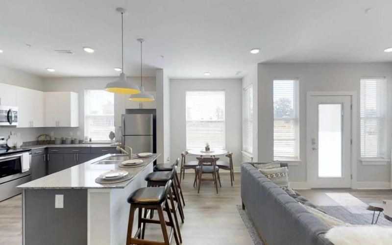 a kitchen and a living room with a couch and a table