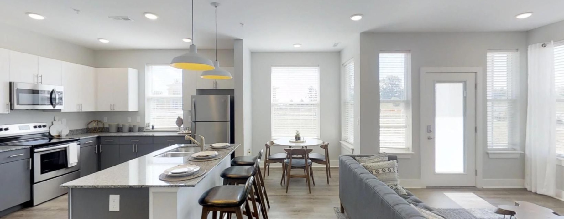 a kitchen and a living room with a couch and a table