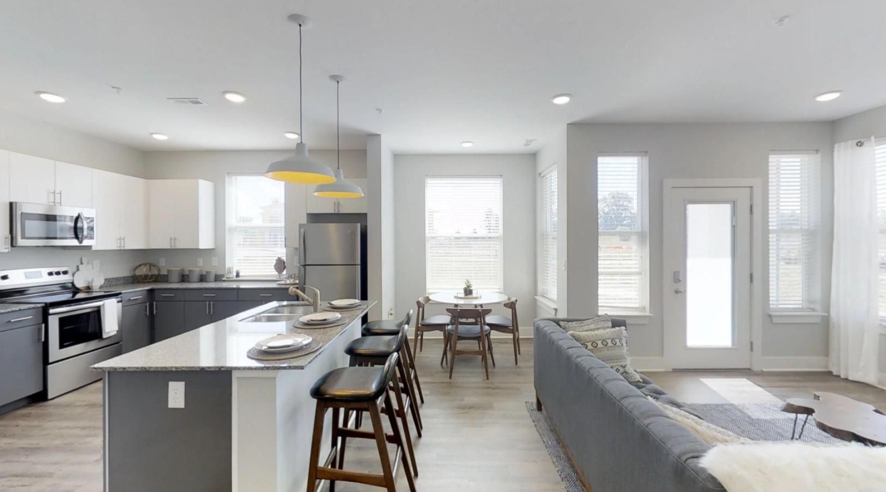 a kitchen and a living room with a couch and a table